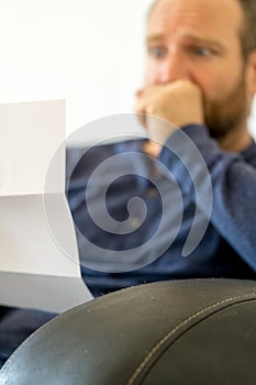 Man reacting to bad news he receives in a letter selective focus