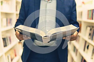 man read book in a bookstore. A businessman buys a book as a gift. student in book shop or library