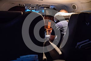 A man read book on the small private jet plane at the night under the light