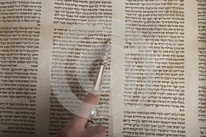 Man reading from an ancient torah scroll up close