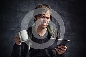 Man Reading Bad News on Digital Tablet Computer