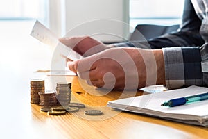 Man reading bank statement, check reminder, tax refund document.