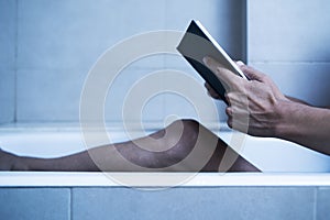 Man reading in bathtub in a mysterious atmosphere