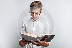 Man reading Bible, white background, book in hand close-up