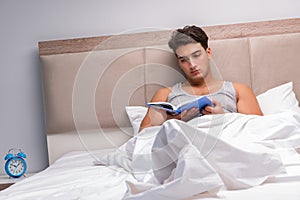 The man reading book in the bed