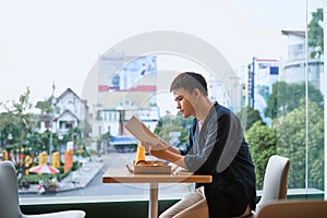 Man reading a book in a coffee shop