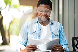 Man reading a book at coffee shop.