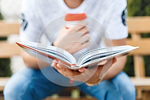 Man reading a book and drinking coffee.Young man resting