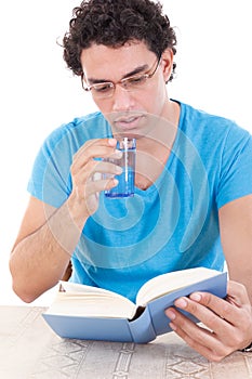 Man reading book while drinking healthy water from a glass