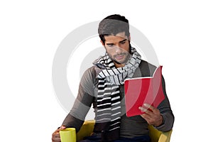 Man reading book while having coffee