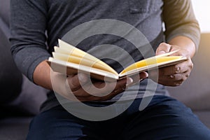 Man reading a book and holding cup of coffee Sit Read Knowledge