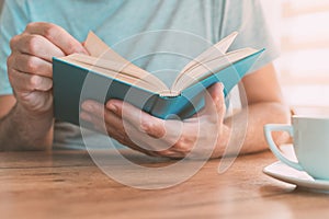 Man reading book at home, enjoying a good read alone