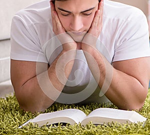 Man reading book at home on floor