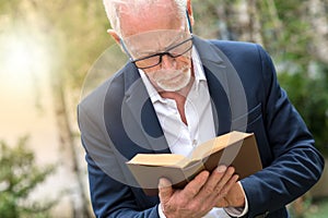 Man reading a book outdoors, light effect