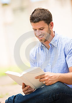 Man reading book outside