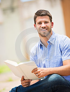 Man reading book outside