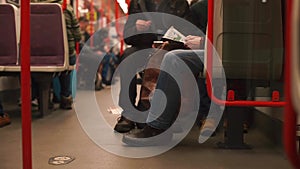 A man reading a book in a train carriage by public transport.