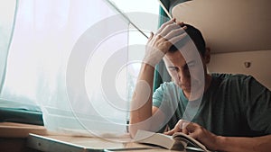 Man reading a book in a train long journey. railroad travel concept coach train journey. view beautiful from the window