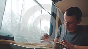 Man reading a book in a train long journey. Railroad travel concept coach train journey. View beautiful from the window