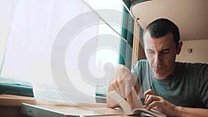 Man reading a book in a train long journey. railroad travel concept lifestyle coach train journey. view beautiful from