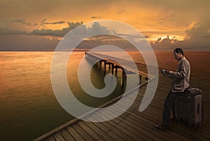 Man reading a book on wood bridge