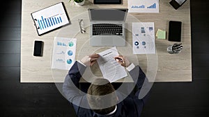 Man reading business contract, concluding agreement with partner, top view