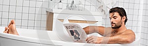 Man reading business newspaper while taking