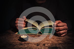 Man reading by candle light