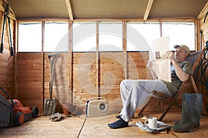 Man reading in garden shed