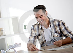 Man reading instructions assembling plane toy