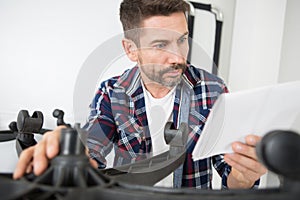 man reading instructions to assemble office chair