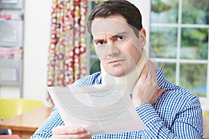 Man Reading Letter After Receiving Neck Injury