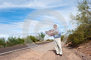 Man reading map on deserted road photo