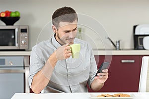 Man reading message on phone at breakfast