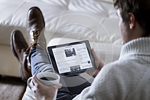 Man Reading News App on Tablet