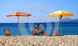 Man reading newspaper on beach