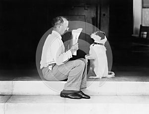 Hombre lectura periódico su el perro 