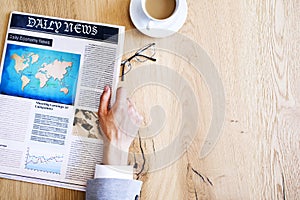 Man reading newspaper on table