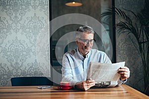 Man reading newspapers in cafeteria