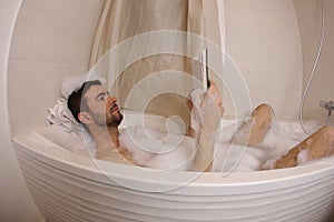 Man reading a novel in the bathtub