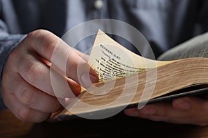 Man reading old holy Bible, closeup view