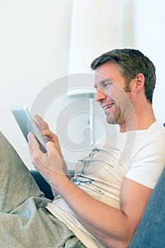 Man is reading a red book, surfing with tablet pc