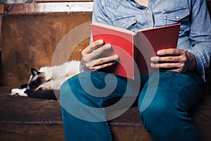 Man reading on sofa with cat