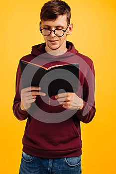 Man is reading and studying the Bible, the man is holding the Bible in his hands. Bible reading over yellow background