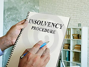 Man reads the insolvency procedure in the book.