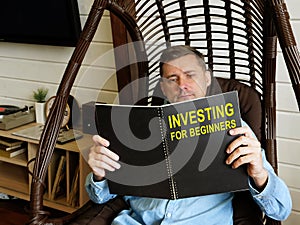 Man reads investing for beginners at home.