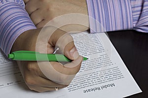 A man reads a model release before signing it.