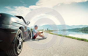 Man reads roads map sitting near his cabriolet