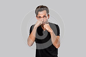 Man ready to fight standing in a boxing pose isolated over grey background.