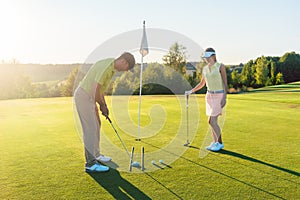 Man ready to hit the golf ball while exercising with his game pa